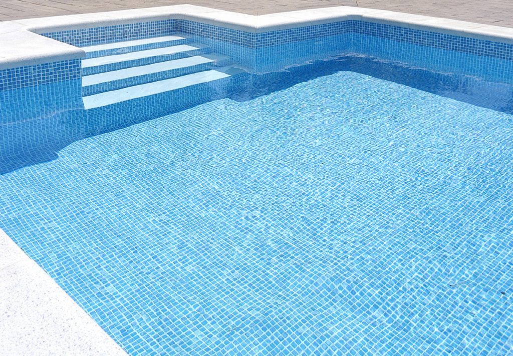 Krásny vonkajší bazén so skimmerom vyhotovený na mieru podľa projektovej dokumentácie - murovaný fóliový bazén, fólia MOSAIC ALKORPLAN3000, modrá voda, modro biela mozaika