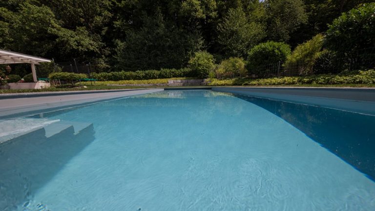 Krásny vonkajší bazén s prelivom, murovaný so skimmerom z fólie LIGHT GREY ALKORPLAN2000 podľa projektovej dokumentácie, bledošedá farba fólie, bledošedá voda