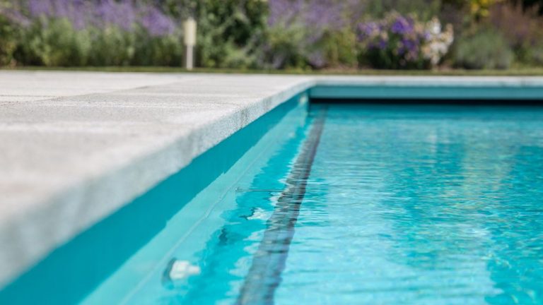 Krásny vonkajší bazén s prelivom, murovaný so skimmerom z 3D fólie CARIBBEAN GREEN ALKORPLAN2000 touch podľa projektovej dokumentácie, zelená farba fólie, bledomodrá voda